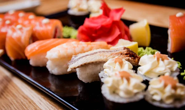 Sushi set. Rolls with salmon, eel and red caviar on a wooden plate. Restaurant. — Stock Photo, Image