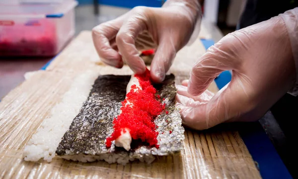Proceso de hacer sushi y rollos en la cocina del restaurante. Chefs manos con cuchillo . —  Fotos de Stock