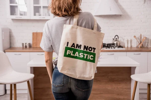 Young girl holding a cloth bag. At the kitchen. I am not plastic. 