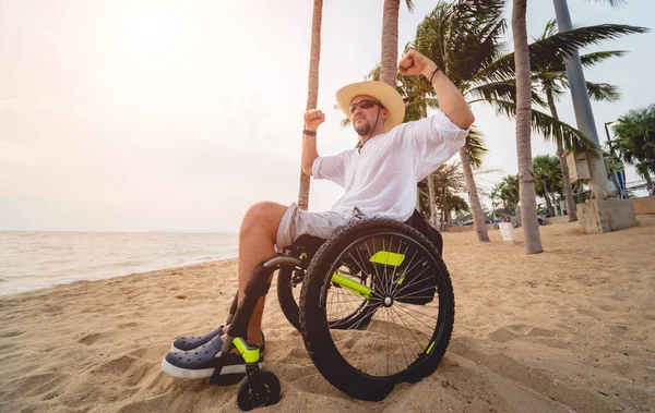 Disabled man in a wheelchair on the beach. — Stock fotografie