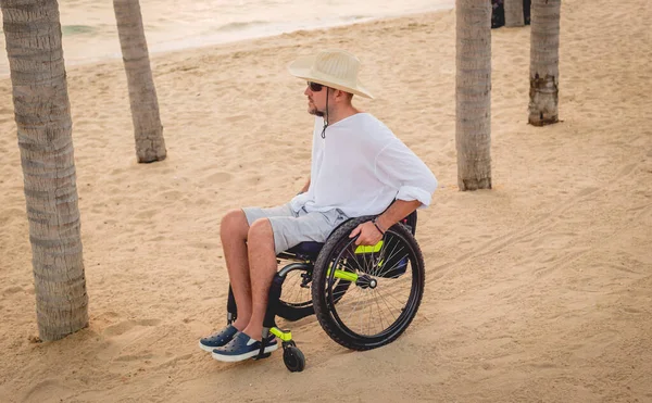 Disabled man in a wheelchair on the beach. — Stock fotografie