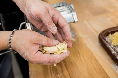 Şef makarna makinesiyle hamur topluyor. Makarna makinesi. 