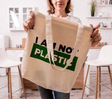 Young girl holding a cloth bag. At the kitchen. I am not plastic.