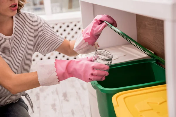 Young girl sorting garbage at the kitchen. Concept of recycling. Zero waste