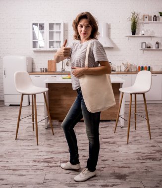 Young girl holding a cloth bag. At the kitchen. I am not plastic.