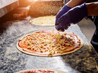 Pizza yapma süreci. Kafe mutfağında pizza yapan aşçının elleri.