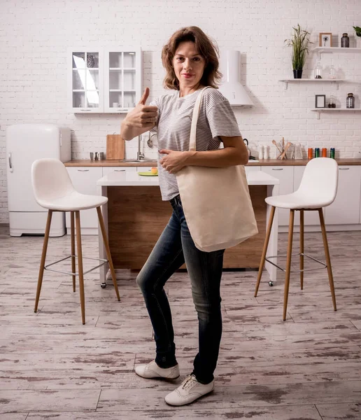 Молодая девушка держит мешок с тряпкой. На кухне. Я не пластик. . — стоковое фото