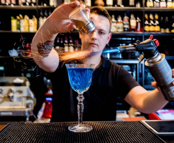 Il barista prepara un cocktail con uno spettacolo di fuoco al bar . — Foto Stock