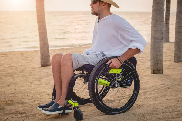 Disabled man in a wheelchair on the beach. — Stock fotografie