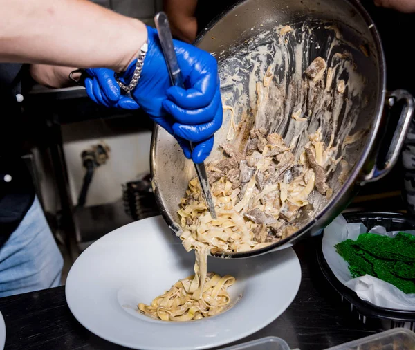 Chef cuisinier pâtes avec de la viande dans la poêle. Cuisine italienne. Restaurant . — Photo