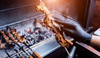 Şef ızgarada leziz biftek ve domuz barbeküsü pişiriyor. Gürcü restoranı.