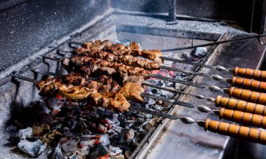 Şef ızgarada leziz biftek ve domuz barbeküsü pişiriyor. Gürcü restoranı.