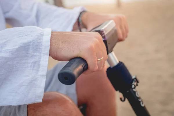 Disabled man in a wheelchair with electric scooter on the beach — Stock Fotó