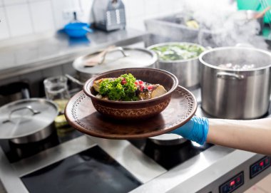 Roasted chicken with potato and vegetables on kitchen stove. 