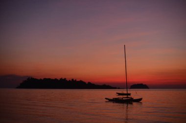 Tropiklerdeki sahilde güzel bir gün batımı. Gökyüzü ve okyanus
