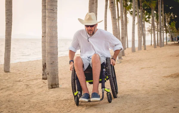 Hombre discapacitado en silla de ruedas en la playa . —  Fotos de Stock