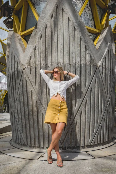 Young sexy woman in sunglasses posing near gray wall. — Stock Photo, Image