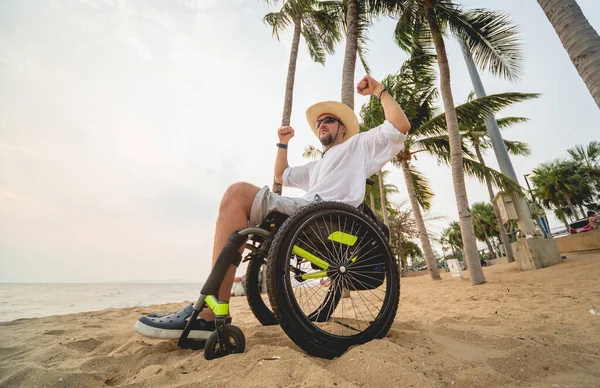 Disabled man in a wheelchair on the beach. — Stock fotografie