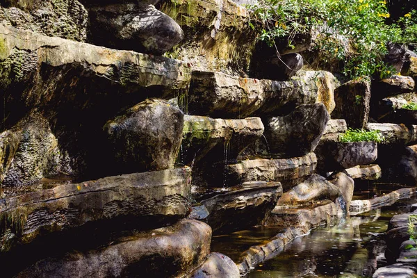 Cascata artificiale all'orto botanico. Pietre e acqua — Foto Stock