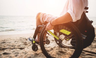Disabled man in a wheelchair on the beach.