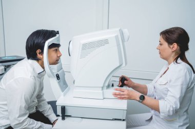 Bir göz doktoruna danışıyorum. Genç Asyalı erkek ve kadın doktor 