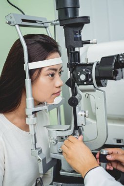 Bir göz doktoruna danışıyorum. Genç Asyalı kadın ve doktor 