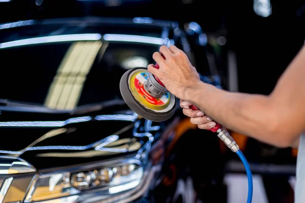 Arbetaren polerar en bil med det elektriska verktyget. — Stockfoto