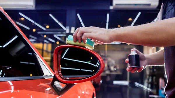 Trabalhador de serviço de carro aplicando revestimento nano em um detalhe do carro — Fotografia de Stock