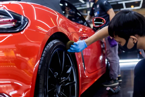 Trabajador de servicio de coche puliendo ruedas de coche con tela de microfibra. — Foto de Stock