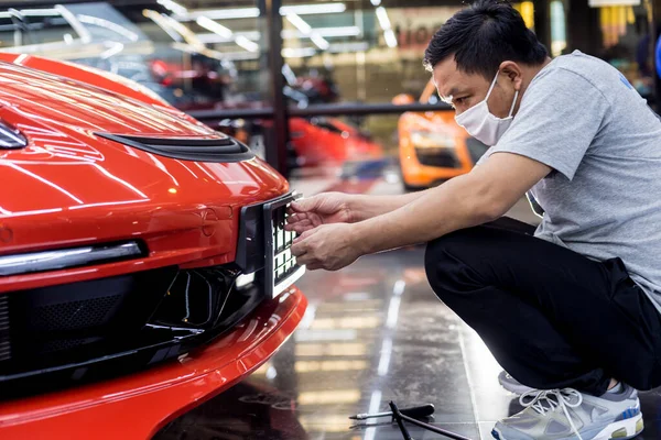 Técnico cambiando el número de placa del coche en el centro de servicio . — Foto de Stock