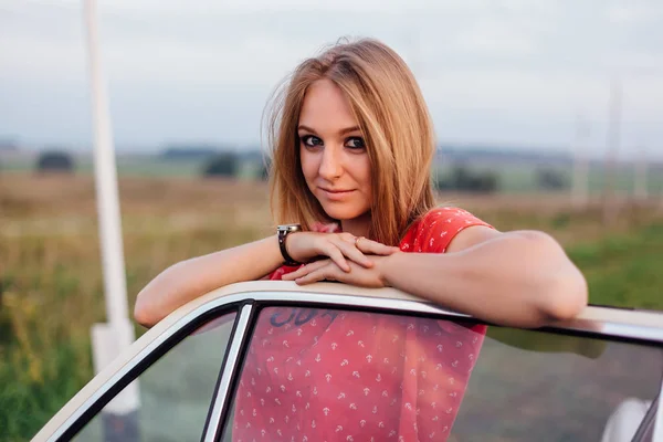 Retrato de uma bela jovem mulher de pé perto de carro retro — Fotografia de Stock