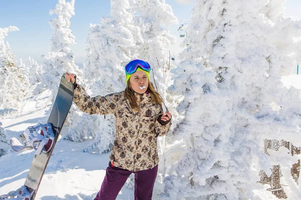Porträt einer jungen lächelnden Frau mit Snowboard — Stockfoto