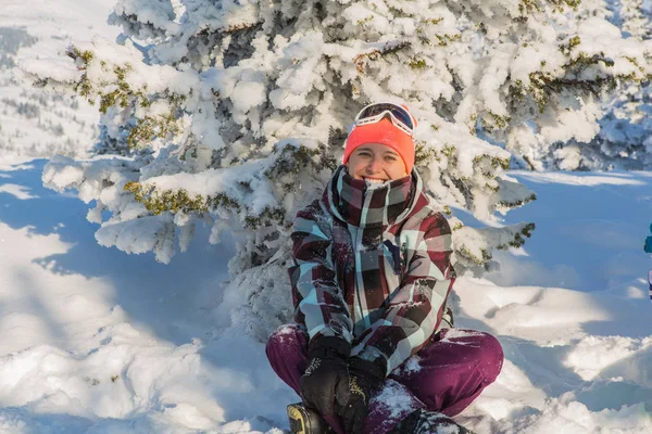 Retrato de una joven sonriente sentada en la nieve — Foto de Stock