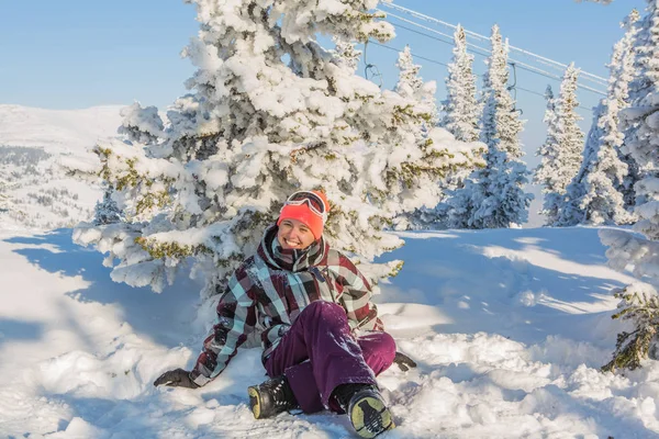 Retrato de una joven sonriente sentada en la nieve — Foto de Stock