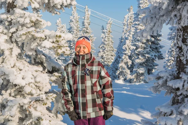 Retrato de una joven sonriente cerca de los árboles cubiertos de nieve — Foto de Stock