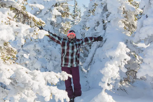 Retrato de una joven sonriente cerca de los árboles cubiertos de nieve — Foto de Stock