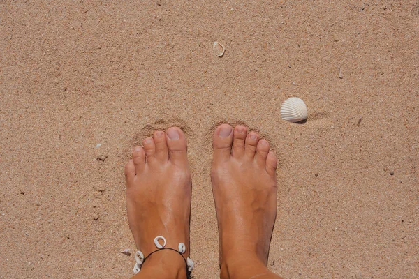 Woman's bare feet covered with sand. — Stock Photo, Image