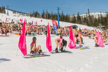 Grup genç mutlu güzel kadını bayrakları ile renkli bikini bir snowboard üzerinde.