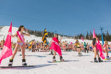 Grup genç mutlu güzel kadını bayrakları ile renkli bikini bir snowboard üzerinde.