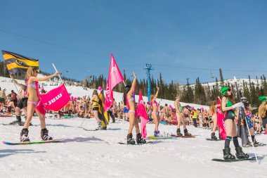 Grup genç mutlu güzel kadını bayrakları ile renkli bikini bir snowboard üzerinde.