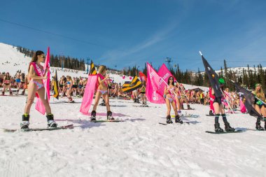 Grup genç mutlu güzel kadını bayrakları ile renkli bikini bir snowboard üzerinde.