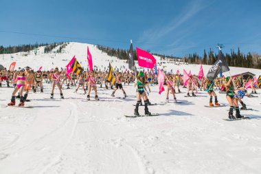 Grup genç mutlu güzel kadını bayrakları ile renkli bikini bir snowboard üzerinde.