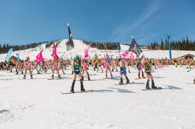 Grup genç mutlu güzel kadını bayrakları ile renkli bikini bir snowboard üzerinde.