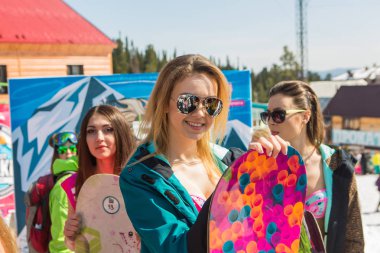 Grup genç mutlu güzel kadını bayrakları ile renkli bikini bir snowboard üzerinde.