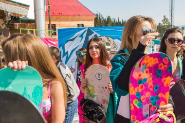 Grup genç mutlu güzel kadını bayrakları ile renkli bikini bir snowboard üzerinde.