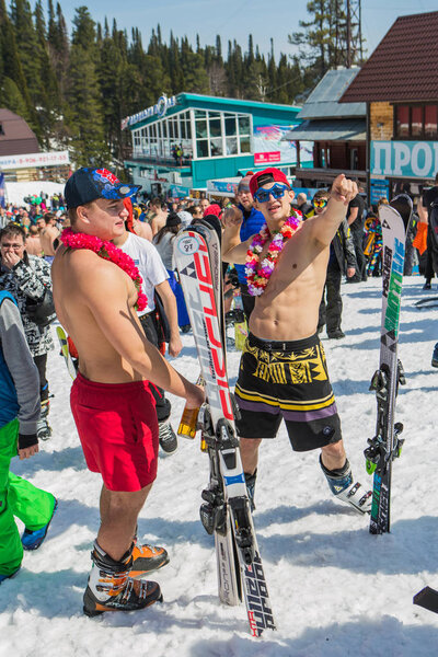 Group of young happy pretty women on a snowboard in colorful bikini with flags.
