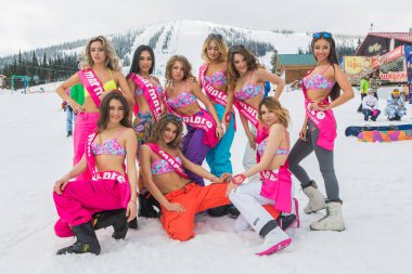 Grup genç mutlu güzel kadını snowboard pantolon ve mountain yakınındaki renkli bikini.
