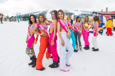 Grup genç mutlu güzel kadını snowboard pantolon ve mountain yakınındaki renkli bikini.