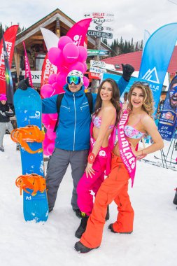 Grup genç mutlu güzel kadını snowboard pantolon ve mountain yakınındaki renkli bikini.