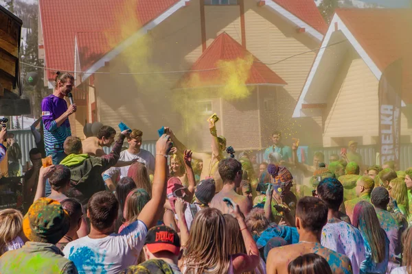 Un grupo de jóvenes lanzando coloridos polvos de holi . — Foto de Stock